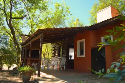 an orange house with a table and chairs outside at Cabañas Altos Del Parque in Villa Ciudad Parque