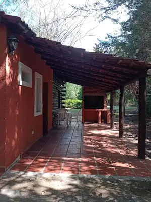 a wooden pergola over a patio of a house at Cabañas Altos Del Parque in Villa Ciudad Parque