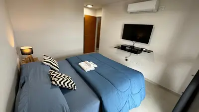a bedroom with a blue bed and a flat screen tv at Guesthouse Luxury in Cordoba