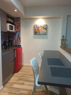a kitchen with a table and chairs in a room at Moderno y cómodo monoambiente céntrico con amenities y SEGURIDAD 24hs in Cordoba
