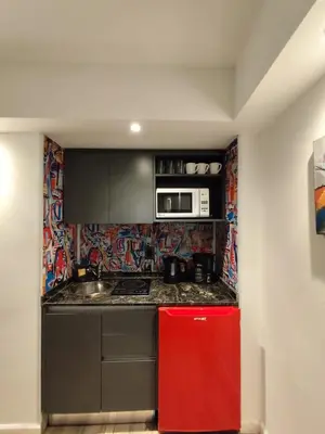 a kitchen with a red refrigerator and a microwave at Moderno y cómodo monoambiente céntrico con amenities y SEGURIDAD 24hs in Cordoba