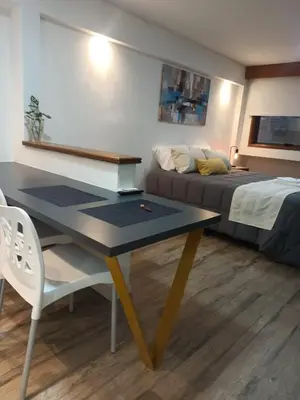 a room with a table and a bed and a couch at Moderno y cómodo monoambiente céntrico con amenities y SEGURIDAD 24hs in Cordoba