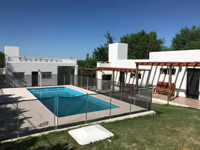 a villa with a swimming pool and a house at Cabañas Al atardecer in Mina Clavero
