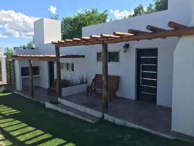 a patio with a bench in front of a house at Cabañas Al atardecer in Mina Clavero