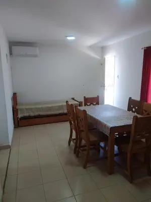 a dining room with a table and chairs and a bench at Luma Departamento, con Pileta in Villa Dolores