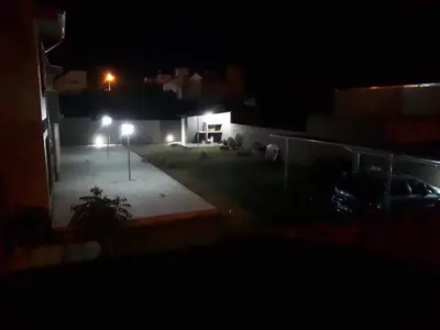 a view of a yard at night with lights at Luma Departamento, con Pileta in Villa Dolores