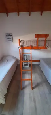 a desk and a chair in a room with two beds at Cabañas Tinkuy II in Cortaderas