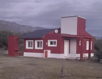 a small red and white house in a field at Cabañas Tinkuy II in Cortaderas