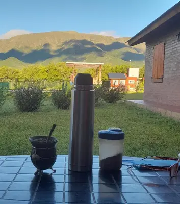 a table with a thermos and a coffee cup on it at Cabañas Tinkuy II in Cortaderas