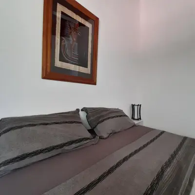 a bed in a room with a picture on the wall at Cabañas Tinkuy II in Cortaderas