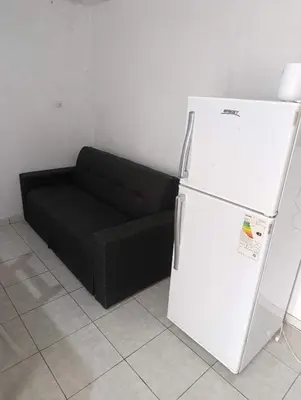 a black couch and a white refrigerator in a room at El ROBLE 2 in Cordoba