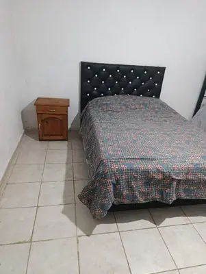 a bedroom with a bed and a wooden table at El ROBLE 2 in Cordoba