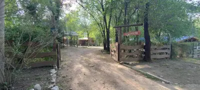 a gate to a dirt road with a fence at Cabañas Calimocho in Santa Rosa de Calamuchita