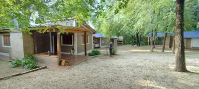 a person standing next to a house with a dog at Cabañas Calimocho in Santa Rosa de Calamuchita