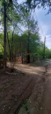 a dirt road with a fence and trees in the background at Cabañas Calimocho in Santa Rosa de Calamuchita