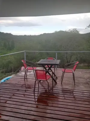 a picnic table and two chairs on a deck at Suspiro de Montaña in La Rancherita