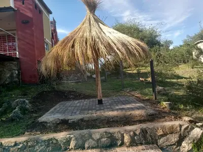 a straw umbrella sitting on a stone slab at Suspiro de Montaña in La Rancherita