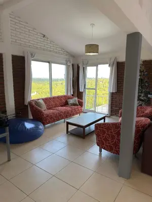 a living room with red couches and a table at Playas Doradas in Villa Anizacate