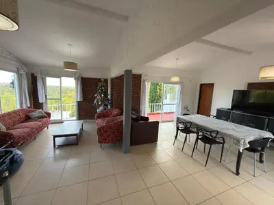 a living room with a table and some chairs and a couch at Playas Doradas in Villa Anizacate