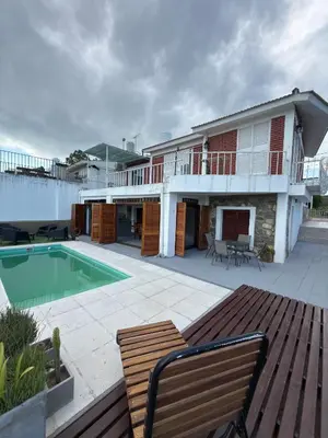 a house with a swimming pool next to a deck at Playas Doradas in Villa Anizacate