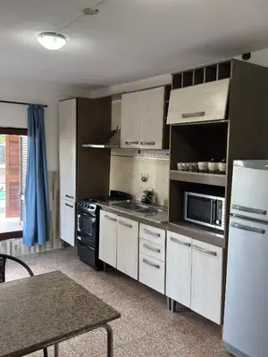 a kitchen with white cabinets and a stove top oven at Playas Doradas in Villa Anizacate