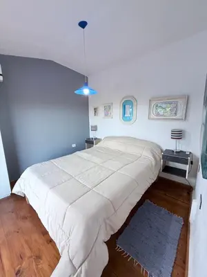 a large white bed in a bedroom with blue walls at Playas Doradas in Villa Anizacate