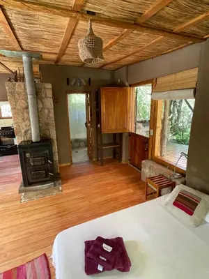 a bedroom with a bed and a stove in a room at Descansa al pie del champaqui escuchando el arroyo in San Javier
