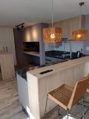 a kitchen with a counter with a chair in it at Village Tower III sobre Av San Martín, Cochera in Villa Carlos Paz
