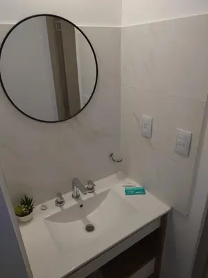 a bathroom with a white sink and a mirror at Village Tower III sobre Av San Martín, Cochera in Villa Carlos Paz