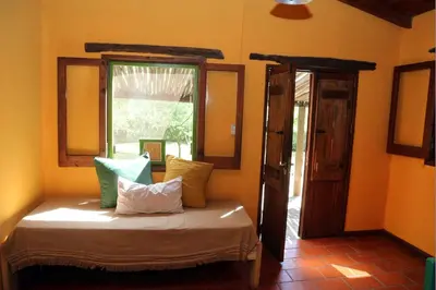 a bed sitting in a room with a window at Tierra linda in Las Chacras (La Paz)
