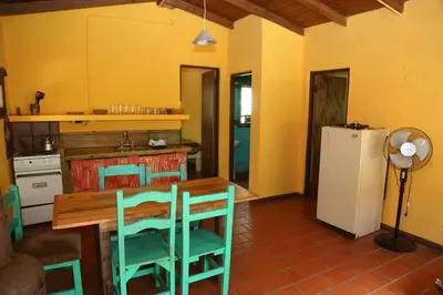 a kitchen with a table and chairs and a refrigerator at Tierra linda in Las Chacras (La Paz)