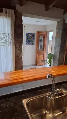 a kitchen with a sink and a wooden counter top at Cabaña Casa Flor Bru in Villa Yacanto