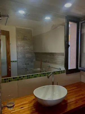 a bathroom with a sink and a large mirror at Cabaña Casa Flor Bru in Villa Yacanto