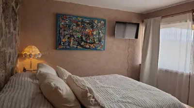 a bedroom with a bed and a painting on the wall at Cabaña Casa Flor Bru in Villa Yacanto