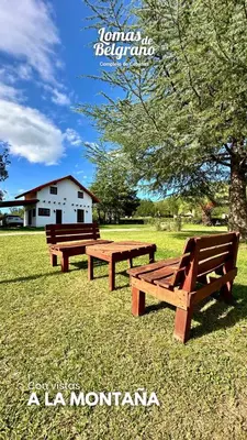 three wooden benches sitting in a field with a tree at Lomas de Belgrano Oficial cabaña 1 in Villa General Belgrano