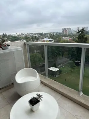 a balcony with a toilet and a view of a city at CERRO DE LAS ROSAS Departamento amoblado con pileta climatizada in Cordoba