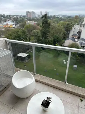 a balcony with a toilet and a table with a view at CERRO DE LAS ROSAS Departamento amoblado con pileta climatizada in Cordoba