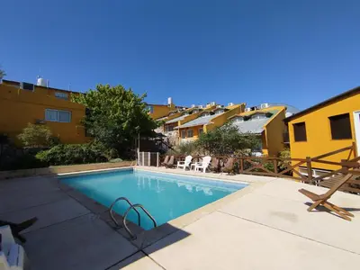 a swimming pool in a yard with some buildings at Complejo EL ALTO in Tanti