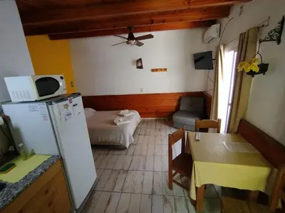 a small kitchen with a refrigerator and a table at Complejo EL ALTO in Tanti