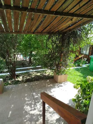 a wooden pergola with a wooden bench under it at Complejo EL ALTO in Tanti