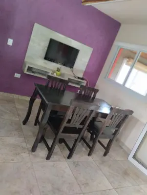 a dining room table with two chairs and a tv at Cabañas Potrero de Garay in La Estancia