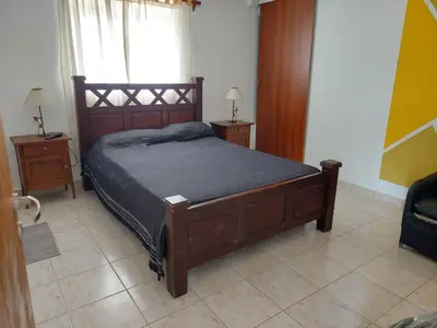 a bedroom with a wooden bed and two night stands at EnlodelLuly in Villa Carlos Paz
