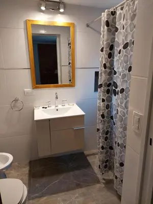 a bathroom with a sink and a toilet and a mirror at EnlodelLuly in Villa Carlos Paz