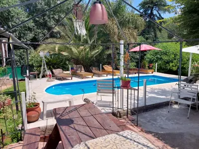 a pool with a table and chairs and an umbrella at EnlodelLuly in Villa Carlos Paz