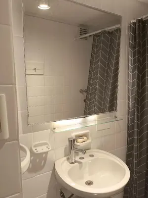 a white bathroom with a sink and a mirror at Refugio en el centro in Cordoba