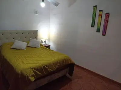 a bedroom with a bed with a green blanket at Duplex la casita de papá in Mina Clavero