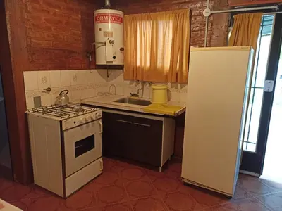 a small kitchen with a stove and a refrigerator at Duplex la casita de papá in Mina Clavero