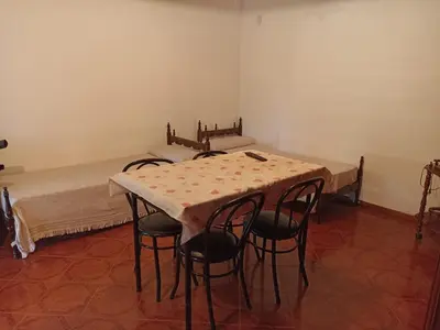 a room with a table with chairs and a bed at Duplex la casita de papá in Mina Clavero