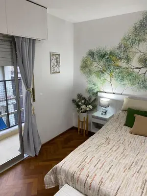 a bedroom with a bed with a painting on the wall at Departamento Centro Córdoba con Cochera Privada in Cordoba