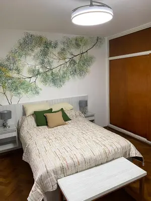 a bedroom with a bed with a painting on the wall at Departamento Centro Córdoba con Cochera Privada in Cordoba
